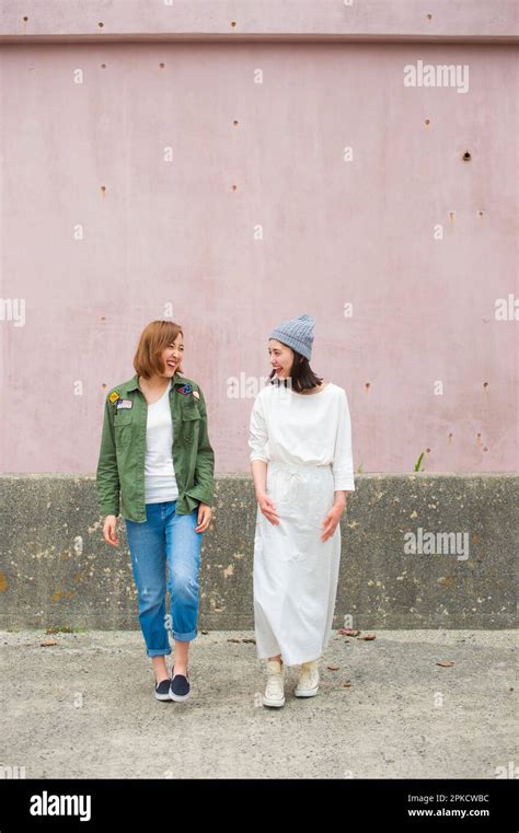 2 women in their 20s talking with friends Stock Photo - Alamy