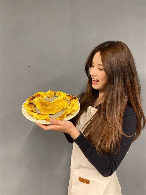 A Woman Holding A Plate With Food On It