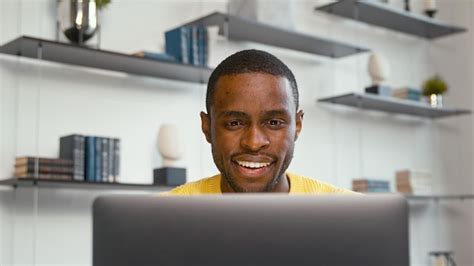 Homem sorridente trabalhando no computador portátil no escritório em