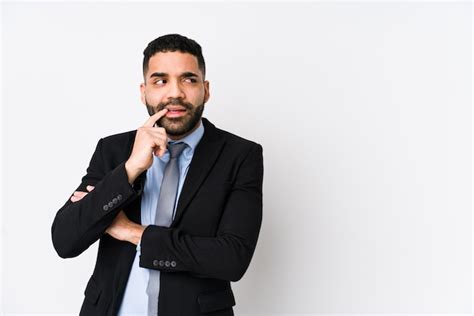 La Mujer De Negocios Latina Joven Contra Una Pared Blanca Se Relaj Pensando En Algo Mirando Un