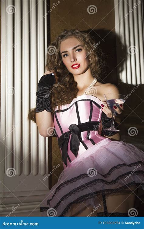 Femme Sexy De Cabaret Dans Le Corset Posant Avec Un Verre Lingerie