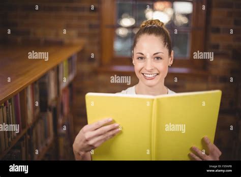 Blonde Teacher Reading Book In The Library Stock Photo Alamy