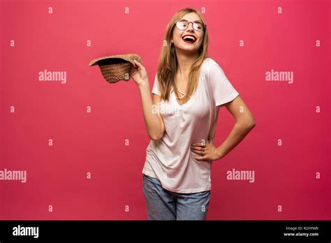 Studio Portrait Of Cheerful Female Model Holding Summer Hat And Smiling Blonde Girl In