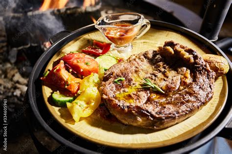 The Big Piece Of The Grilled Meat And Vegetables Lies On A Plate Juicy