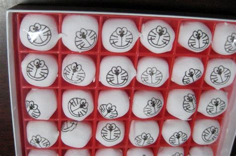 A Red Tray Filled With Lots Of Cartoon Faces On Top Of White Foam Balls