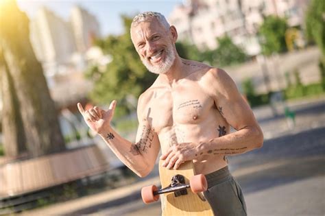 Premium Photo A Half Naked Skateboarder Holding A Skateboard