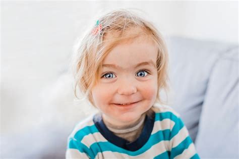 Premium Photo Close Up Portrait Of Cute Girl Smiling While Sitting At