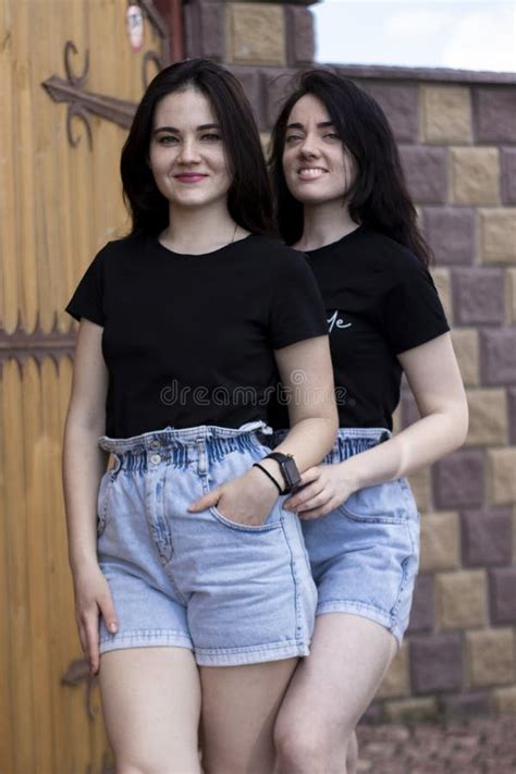 Twee Jonge Brunette Vrouwen In Een Zwart Shirt En Denim Twijfelt Aan