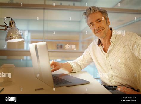 Mature Businessman Looking At Camera At Desk Stock Photo Alamy