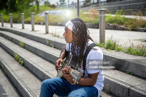 Young Dread Hair Guy Playing The Guitar And Singing Out Door High Res
