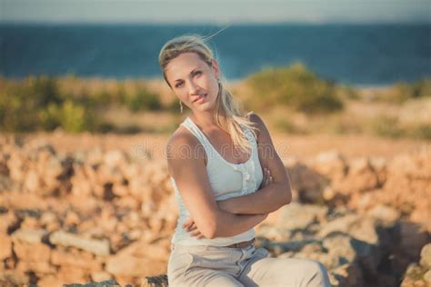 La Donna Bionda Seducente Di Signora Con Le Gambe Nude Sexy Mette E Arma L Uso Sulle Spalle Blu