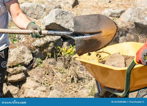 Worker At An Archaeological Excavation Site Dumping Soil With A Shovel