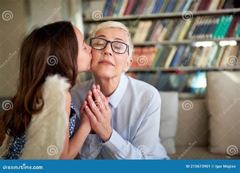 Granddaughter Kissing With Love Her Mature Woman Grandmother Preschooler At Home On Sofa Royalty