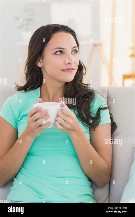 Pretty Brunette Relaxing On The Couch With Coffee Stock Photo Alamy