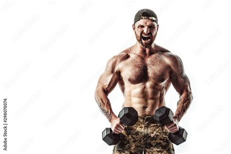 Muscular Athlete Bodybuilder Man In Camouflage Pants With A Naked Torso Workout With Dumbbell On