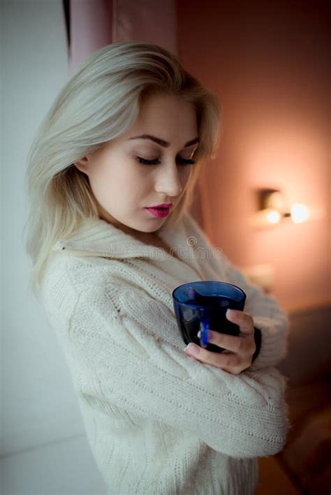 Blue Eyed Blonde In Lingerie And Black Stockings Looks From Below To The Camera Stock Photo