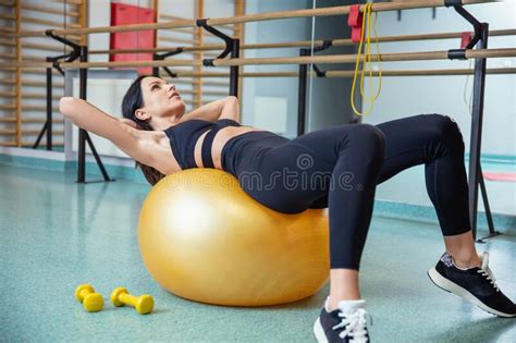 Brunette Joven Y En Forma Hace Ejercicios Con Sus Abdominales Con La Bola De Ajuste Imagen De
