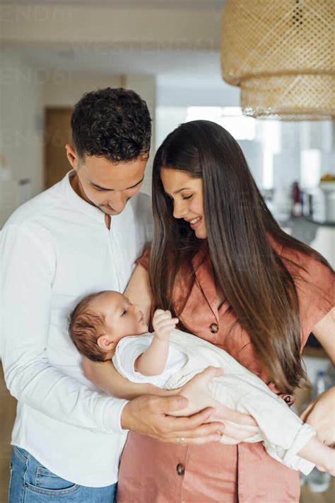 loving parents carrying baby boy  home stock photo