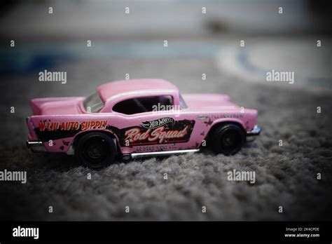 The High Angle View Of A Pink Mattel Hot Wheels Brand Toy Chevy Car Model On The Gray Carpet