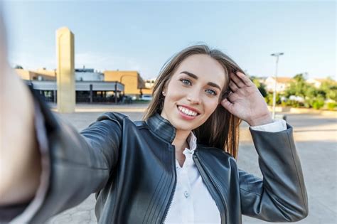 Premium Photo Blueeyed Blonde Woman In Leather Jacket Smiling Takes A Selfie With Her Camera