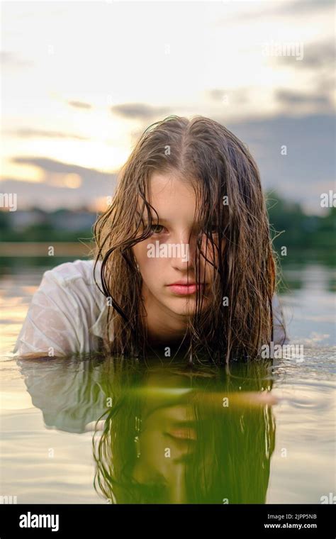 Girl In A White Shirt Sits In The Water Of A Lake Stock Photo Alamy