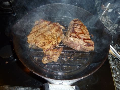 Steaks grilling on top of a Griswold skillet grills set in a No 8