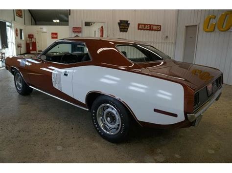 A Brown And White Muscle Car Parked In A Garage