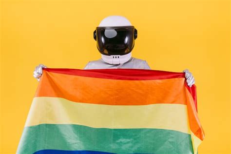 Premium Photo Gay Man Dressed As An Astronaut With A Helmet And Silver Suit Holding A Flag Of