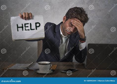 Depressed And Stressed Attractive Hispanic Man In Suit And Tie Working