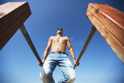 A Male Athlete With A Naked Torso Is Training On A Horizontal Bar Stock Photo Image Of