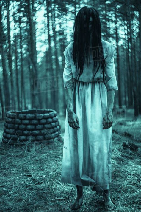 Girl With Long Black Hair In Image Of Scary Ghost Zombie Stands Among