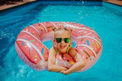 Chica En Bikini Desnuda Flotando En Un Donut De Goma En La Piscina Foto Premium