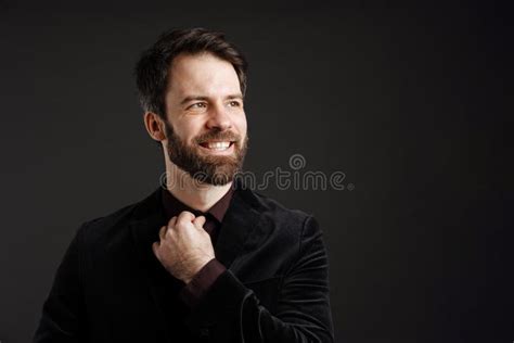 Bearded Happy Man In Black Jacket Smiling And Looking Aside Stock Photo