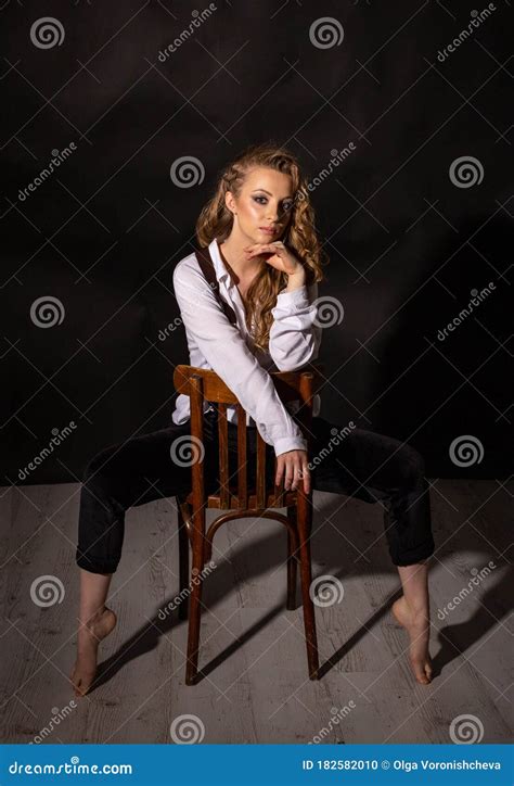 Portrait Vertical D Une Blonde Aux Pieds Nus Assis Sur Une Chaise Dans Le Studio Photo Stock