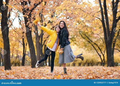 Pretty Woman And Teen Girl Are Posing With Bunch Of Maple`s Leaves In