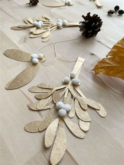 Some White And Gold Decorations Are Laying On A Table With Pine Cones