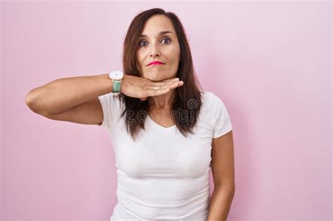 Middle Age Brunette Woman Standing Over Pink Background Cutting Throat