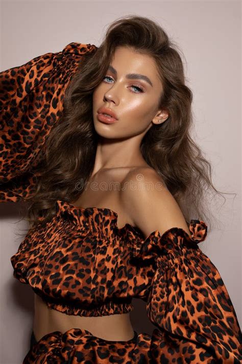 Hot Female Model Wearing A Leopard Print Outfit And Glowing Make Up Posing For A Photoshoot