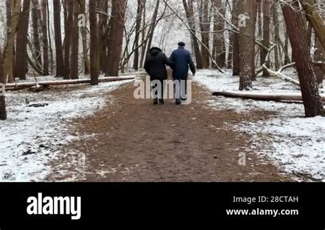 Mature Couple Going On Snowy Path At Winter Pine Forest Senior Husband