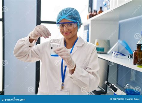 Joven Latina Con Uniforme Científico Mezclando Líquido En Laboratorio Imagen de archivo Imagen