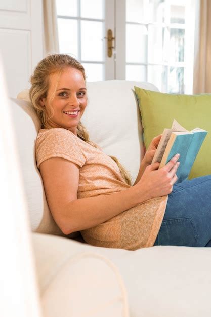 Premium Photo Pretty Blonde Reading A Book Sitting On The Couch In The Living Room