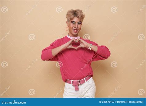 Youth Asian Transgender LGBT Looking At Camera While Posing Isolated Over Nude Color Background