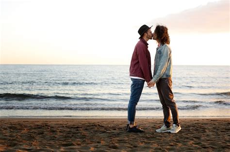 Vista do casal gay sendo carinhoso e passando tempo juntos na praia Foto Grátis