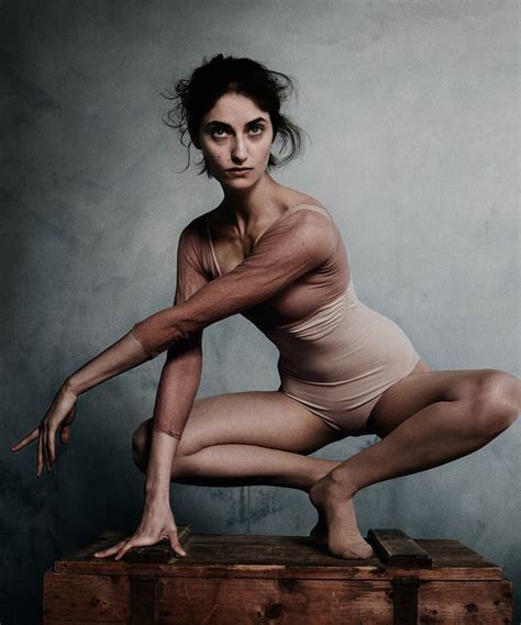 A Black And White Photo Of A Woman In A Bodysuit Crouching On A Box