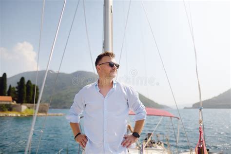 Handsome Mature Man Aboard Sailboat In Bay Of Kotor Near Town Of Perast On Adriatic Sea In