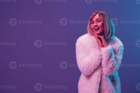 Happy Adorable Blonde Woman In Fluffy Fur Coat Sparkly Dress Fold Hands Posing Isolated In Blue