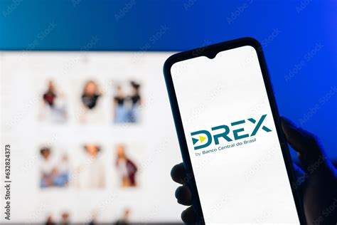hand holding  smartphone displaying  drex logo   blurred