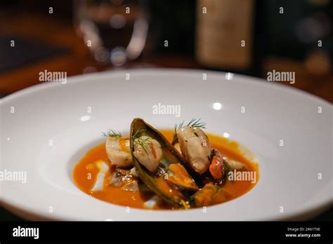 A Bowl Of Steaming Hot Tomato Based Seafood Soup Garnished With Herbs And Spices Ready To Be