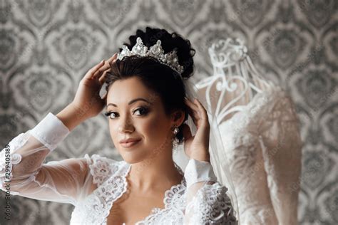 Beautiful Happy Brunette Bride In A Stylish Robe Posing Near Manequin Wedding Dress Morning