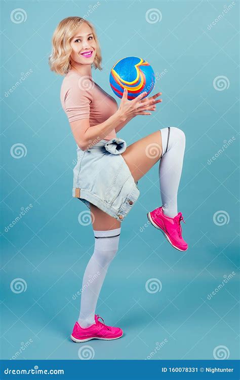 Attractive And Smiling Blonde Woman In A A Sports Suit Pink Sneakers And Gaiters Stockings